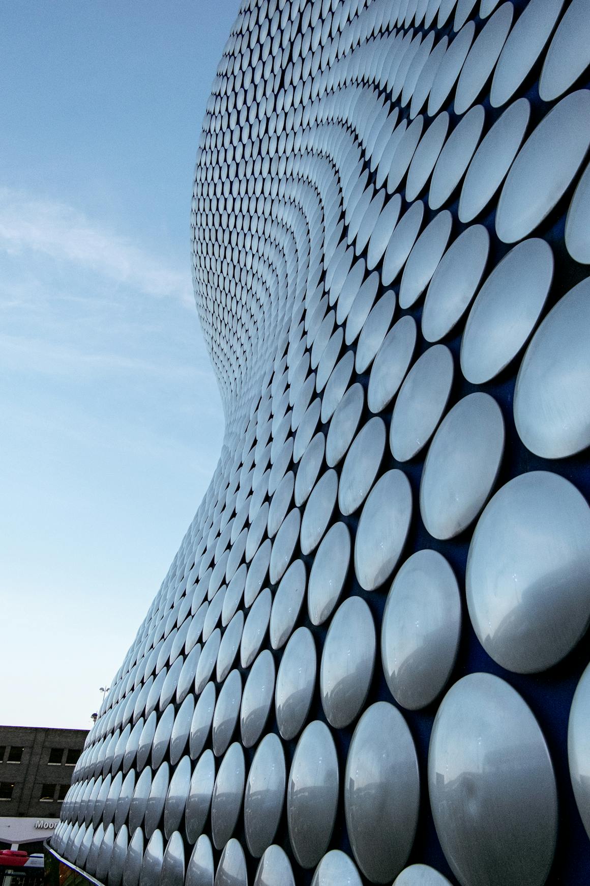 Dynamic facade with circular patterns and modern design in an outdoor setting.